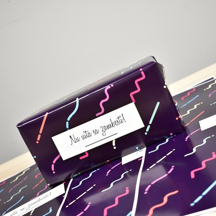 Individuell gestaltetes Geschenkpapier mit Text in einem Rahmen, dunkelvioletter Hintergrund