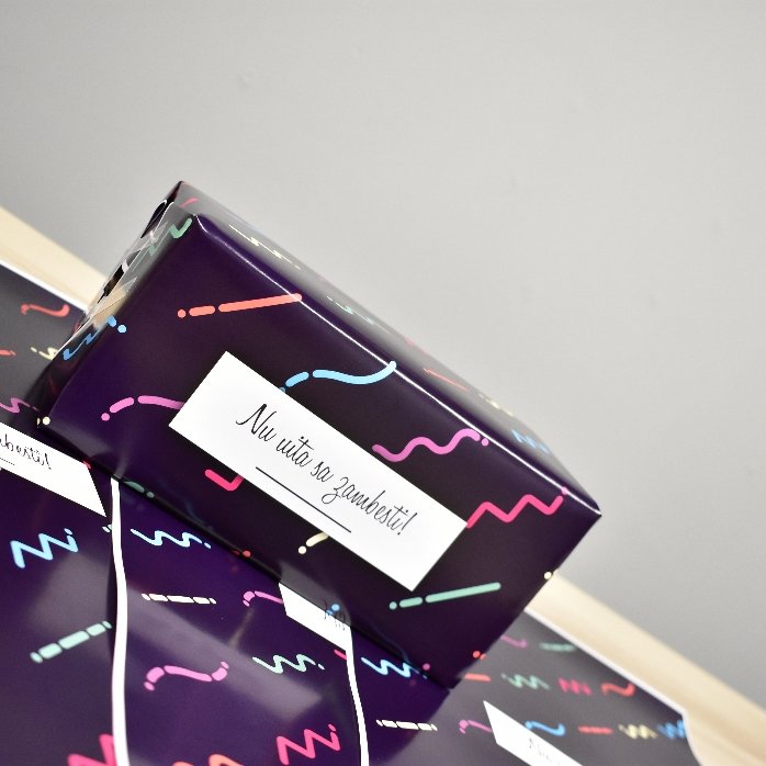 Individuell gestaltetes Geschenkpapier mit Text in einem Rahmen, dunkelvioletter Hintergrund